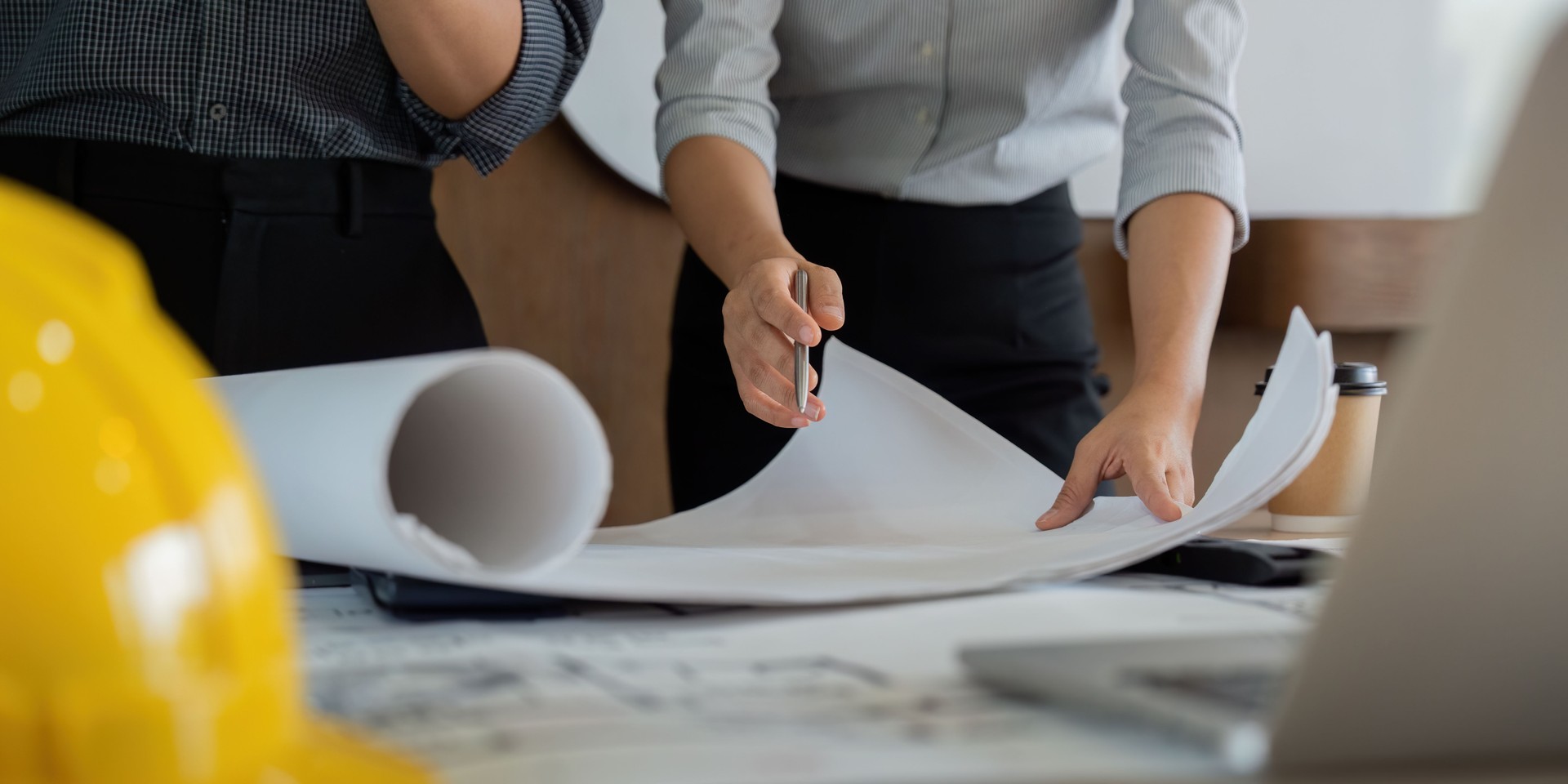 Preparation and Detail. Engineers reviewing vital details and drawings on a work table.
